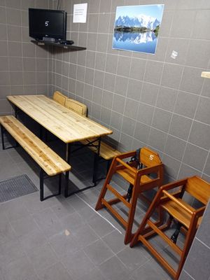une pièce dans laquelle se trouvent une table, des chaises et une télévision