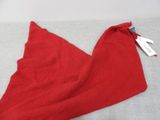 a red towel on a bed with a tag on it