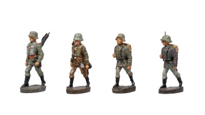 three figurines of men in military uniforms are posed on a white surface