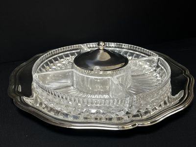 a glass tray with a silver lid on a black table
