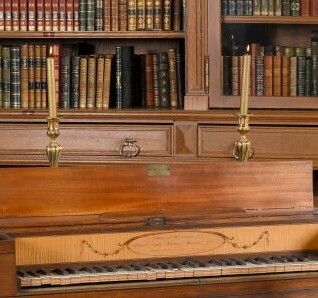 un piano devant une bibliothèque dans une bibliothèque