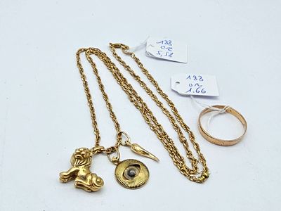 a close up of a gold necklace with a ring and a ring on it