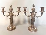 two silver candlesticks sitting next to each other on a table
