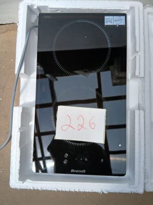 une boîte blanche surmontée d'une plaque de cuisson noire, sur laquelle est posée une note