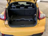 a small yellow car with its trunk open in a parking lot