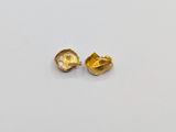 two pieces of gold are shown on a white surface
