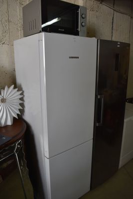 a refrigerator and a microwave on top of it in a room