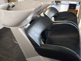 une photo d'un fauteuil de coiffure équipé d'un lavabo et d'un miroir
