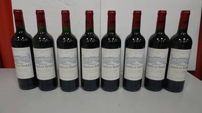 six bottles of red wine are lined up on a table