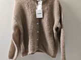 a close up of a sweater hanging on a hanger on a wall