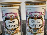 three white and gold canisters sitting on top of a marble counter