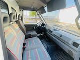 the interior of a white van with a red and blue seat cover