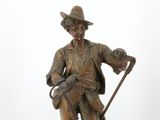 bronze statue of a man with a cane and hat holding a cane
