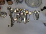 a lot of silver spoons and spoons on the table