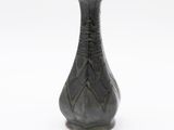 a black vase that is sitting on a white surface