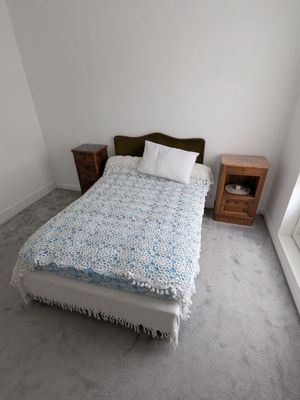 un petit lit dans un coin d'une pièce dotée d'une fenêtre