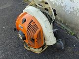 a small blower sitting on the ground next to a wall