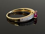 an image of a gold ring with a ruby stone and diamonds