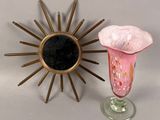 un vase et un motif en rayons de soleil posés sur une table