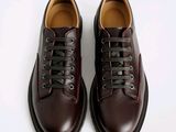 a close up of a pair of brown shoes on a white surface
