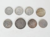 several different coins are arranged in a row on a white surface