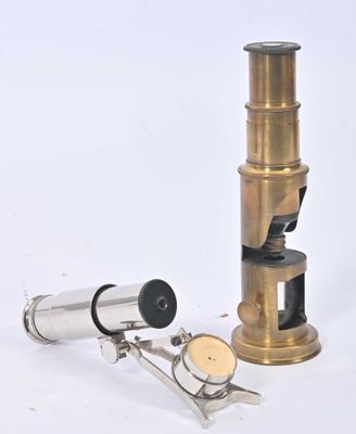 une image représentant un microscope muni d'un support métallique posé sur une surface blanche