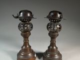 une paire de bougeoirs anciens en bronze surmontés de chapeaux