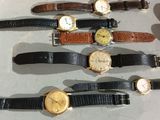 several different types of watches are lined up on a table