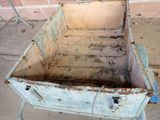 a dirty old metal cart sitting outside on the sidewalk
