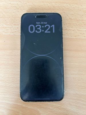 Un iPhone est posé sur une table en bois ; une horloge s'affiche à l'écran.