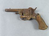 un vieux pistolet jouet rouillé posé sur une surface blanche