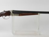 le fusil est exposé dans un présentoir en verre transparent