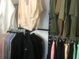 de nombreuses chemises suspendues à un portant dans un magasin de vêtements