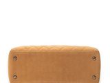 a tan purse with studded handles on a white background