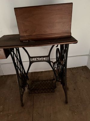 an old sewing machine with a laptop on it