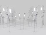 four clear plastic chairs sitting next to each other on a white surface