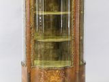 an antique display cabinet with a glass door and gold trimming