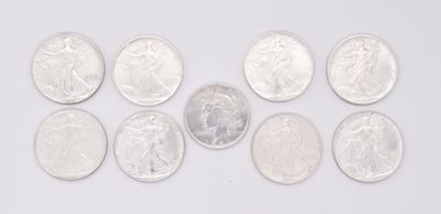 a group of silver coins sitting on top of a white surface