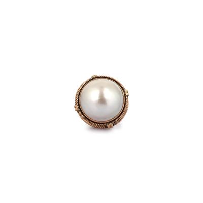 un gros plan d'une bague en perle sur fond blanc