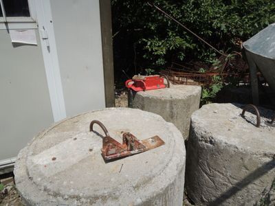 deux piliers en béton sur lesquels est fixée une poignée métallique rouillée