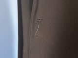 a close up of a black jacket with a small hole in the back