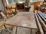 une table au milieu d'une pièce, sur laquelle sont posés de nombreux morceaux de bois
