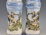 une paire de vases bleus et blancs ornés d'oiseaux, posés sur une table