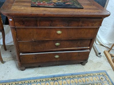 une commode en bois surmontée d'un tableau