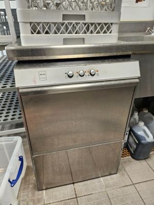 stainless steel dishwasher in a commercial kitchen next to a sink