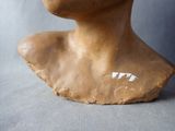 a clay bust of a woman with her eyes closed