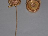 pair of gold tone buttons and a stick with a flower on them