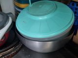 a metal counter top with a bowl and pans on it