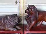 des sculptures représentant un lion et un chien sont exposées devant un miroir