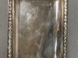 an antique silver plate with a decorative design on it